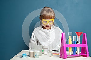 Cheerful little child girl scientist in school lab
