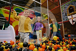 Cheerful little children spending time at daycare indoor playground