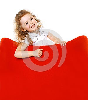 Cheerful little girl on armchair