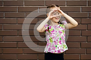 Cheerful little girl child spies closing her eyes with her hands