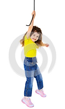 Cheerful little girl hanging on a rope