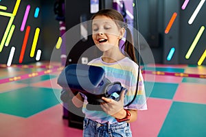 Cheerful little girl holds virtual reality glasses