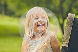 Cheerful little girl laughing on bench