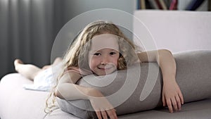 Cheerful little girl looking at camera with smile on face, happy childhood