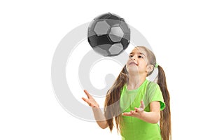 Cheerful little girl plays with ball in studio