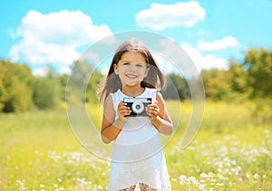 Cheerful little girl with retro camera