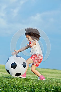 Cheerful little girl runs on grassy meadow playing