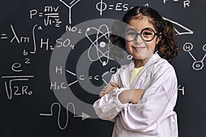 Cheerful little girl science student in lab coat
