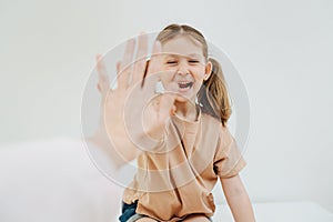 Cheerful little girl with two pony tails giving high five