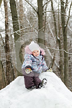 Cheerful little girl wearing warm clothes posing