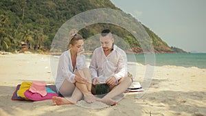 The cheerful love couple holding and eating slices of watermelon on tropical sand beach sea. Romantic lovers two people