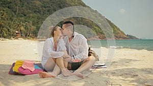 The cheerful love couple holding and eating slices of watermelon on tropical sand beach sea. Romantic lovers two people