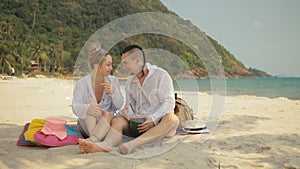 The cheerful love couple holding and eating slices of watermelon on tropical sand beach sea. Romantic lovers two people