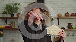 Cheerful lovely female real estate agent holding house key and home model