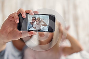 Cheerful lovers photographing themselves on phone