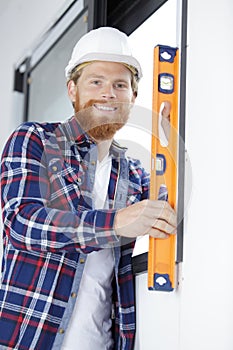 Cheerful male builder using spirit level