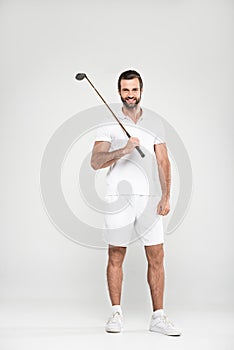 cheerful male golfer in white sportswear with golf club,