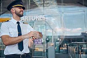 Cheerful male pilot standing on the street