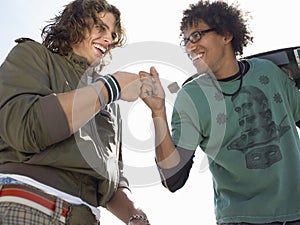 Cheerful Male Skateboarders Giving A Fist Bump