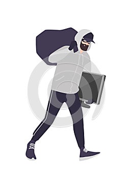 Cheerful male thief wearing mask, cap and hoodie carrying bag and TV. Bearded man commits theft, burglary or