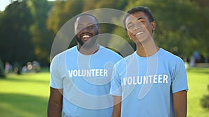 Cheerful male volunteers smiling on camera, eco project participation, charity