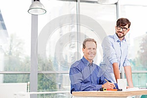 Cheerful male workers are discussing the plan of