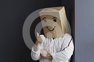 Cheerful man with a bag on his head, with a drawn smiley.