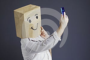 Cheerful man with a bag on his head, with a drawn smiley.