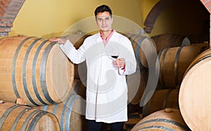 Cheerful man checking ageing process of red wine