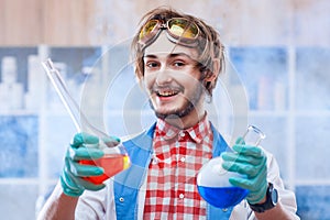 Cheerful man with chemistry flasks