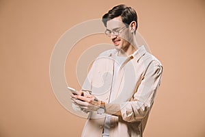 Cheerful man in glasses looking at smartphone isolated