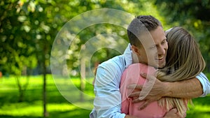 Cheerful man hugging girlfriend, affection closeness, friendly relationship