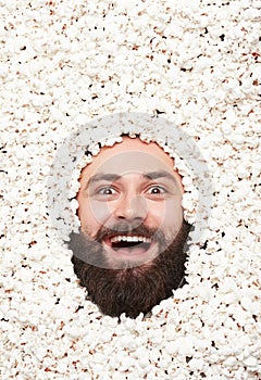 Cheerful man lying in popcorn