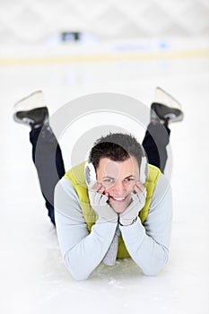 Cheerful man lying on a skating rink