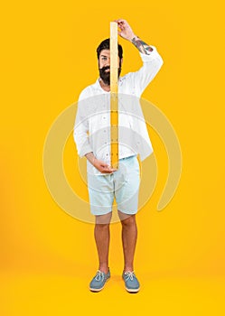 cheerful man with measuring ruler on background. photo of man with measuring ruler.