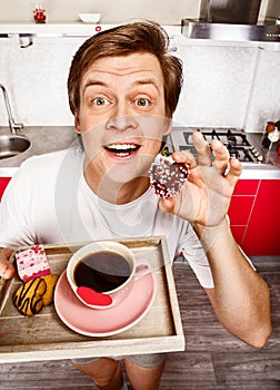 Cheerful man with morning coffee and cookies
