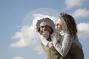 Cheerful Man Piggybacking Woman