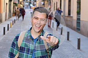 Cheerful man pointing at camera outdoors