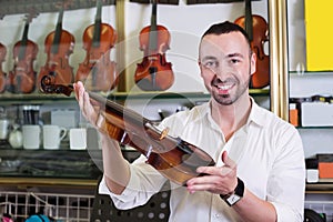 Cheerful man purchasing traditional violins