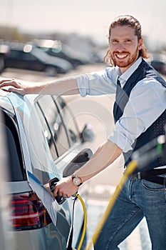 Cheerful man refueling car with petrol