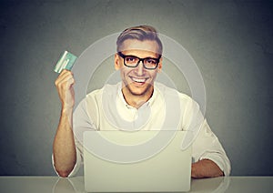 Cheerful man shopping online with card