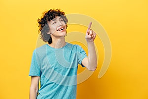 Cheerful man shows thumb up on yellow background