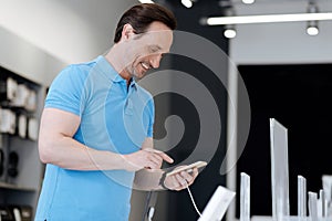 Cheerful man smiling while shopping at electronics store