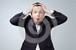 A cheerful man in a suit is surprised. Studio portrait of a surprised young manager