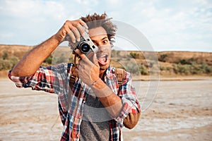 Cheerful man taking pictures and having fun on the beach