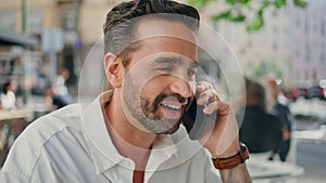 Cheerful man talking cell sharing good news at city closeup. Freelancer laughing