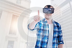 Cheerful man in VR headset his finger to press button