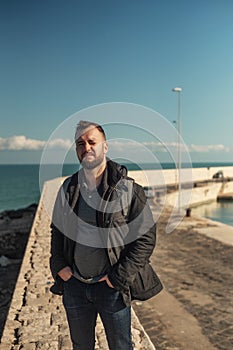 Cheerful man walking pier of port in Bari, Italy