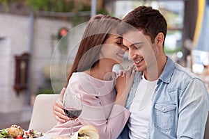 Cheerful man and woman are dating in restaurant