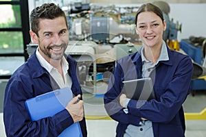 cheerful man and woman industrial looking at camera